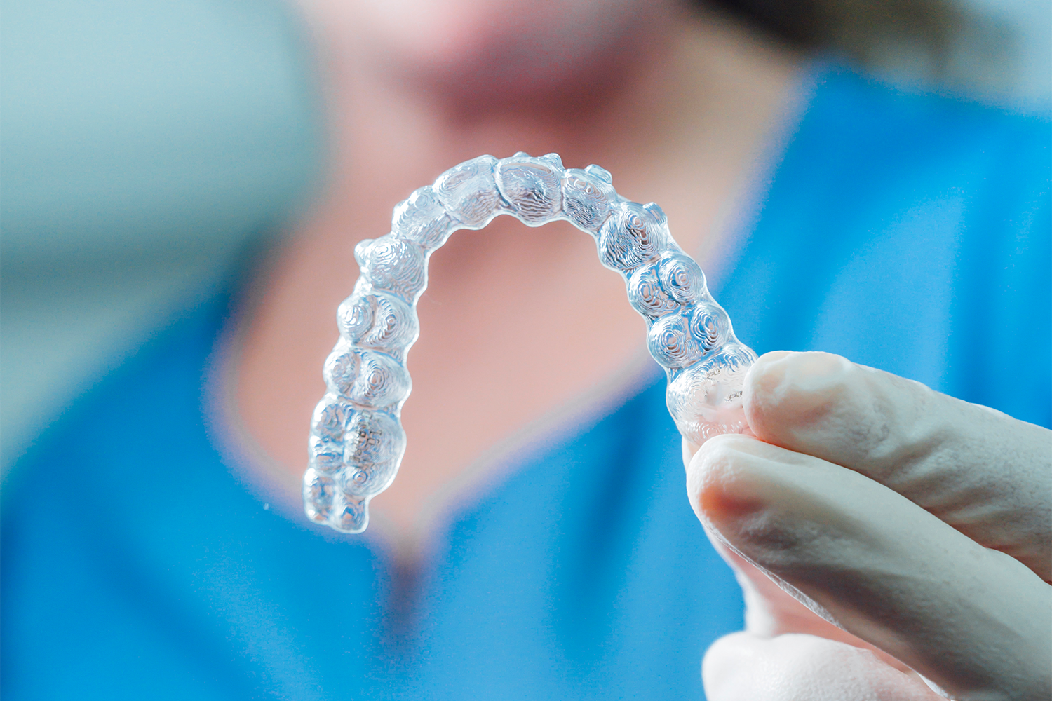adult-woman-holding-clear-dental-retainer-2026-03-19-04-11-50-utc