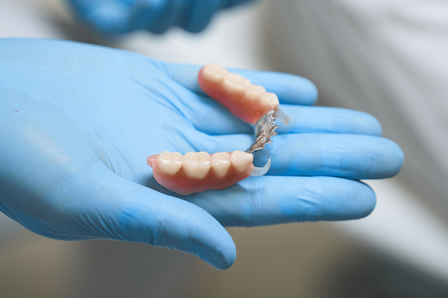 dentist-holding-dentures-in-blue-protective-gloves-2026-09-24-08-09-57-utc